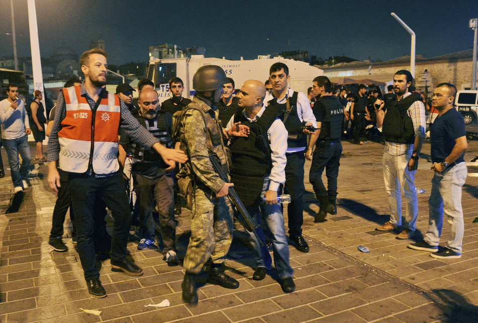 A Turkish police officer, center right, confronts a Turkish army officer, center left, that participated in the coup, after he was apprehended by civilians and handed over, in Istanbul's Taksim square, early Saturday, July 16, 2016. Members of Turkey's armed forces said they had taken control of the country, but Turkish officials said the coup attempt had been repelled early Saturday morning in a night of violence, according to state-run media. (AP Photo/Selcuk Samiloglu)